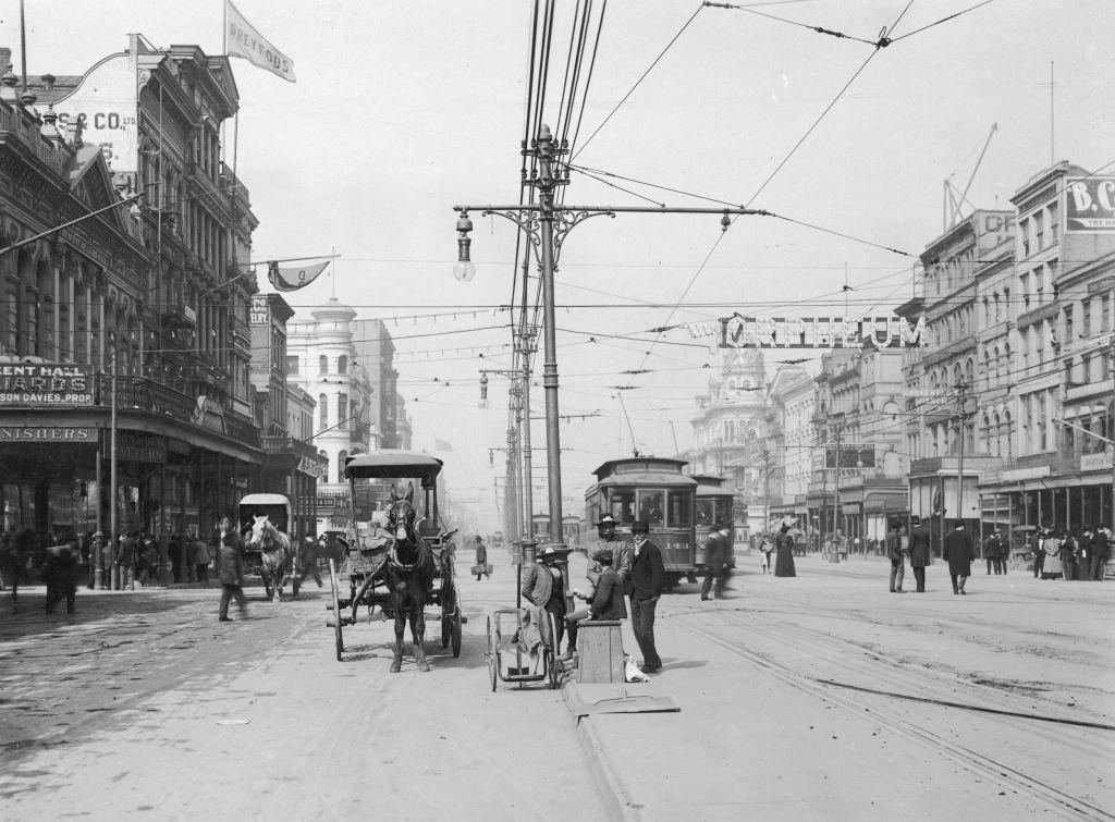 A view of Canal Street, with trolleys running on overhead lines and horsedrawn carriages. New Orleans, 1895.