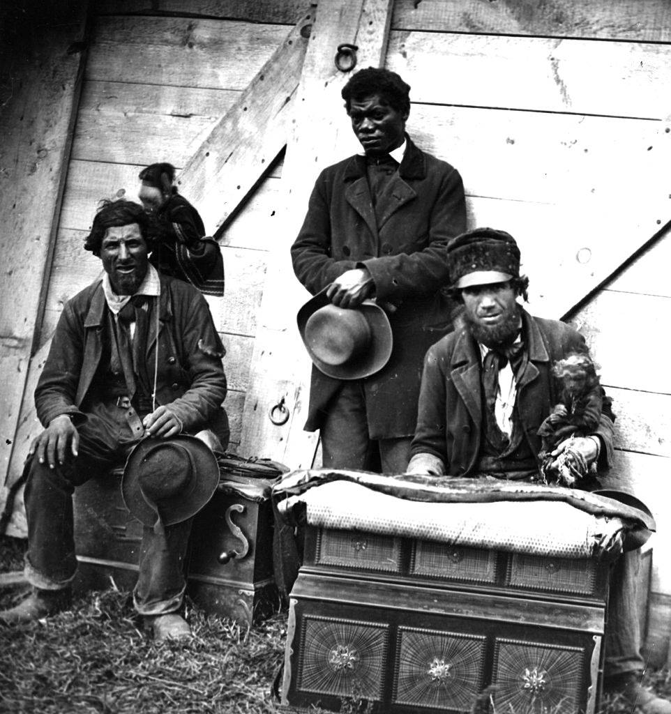 Itinerant street musicians with organs and monkeys, 1860s.