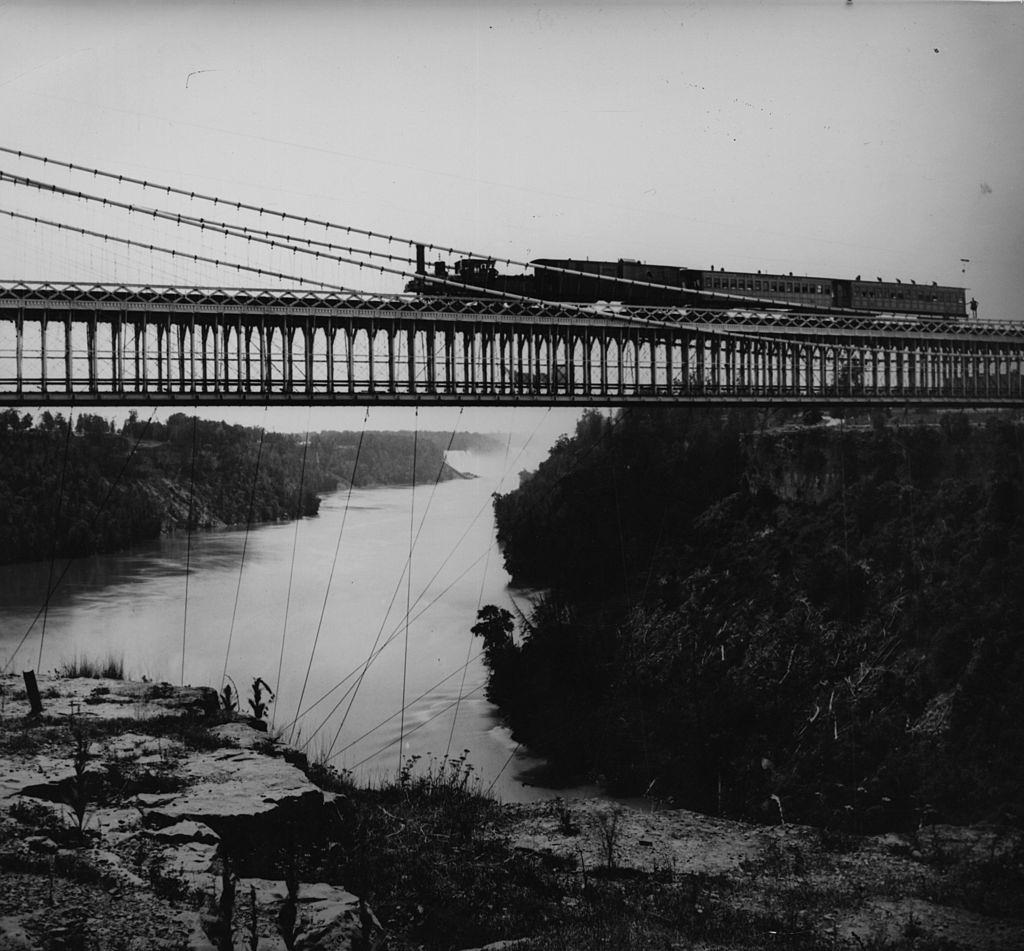 A steam train crosses the Railway Suspension Bridge over the Niagara River, 1860s.