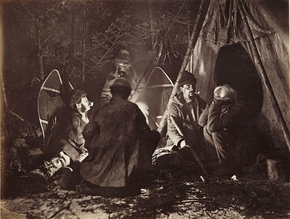 A camp scene, with a group of hunters gathered around a campfire next to their tent, Ottawa, 1860.