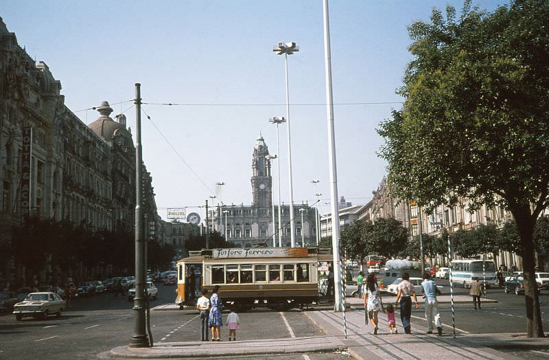 STCP 122, a JG Brill built 4-wheel semi convertible tram probably of 1912, turns at Praca de Liberdade in front of Avenida do Aliados on 12 June 1974