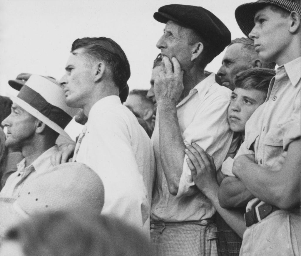 A child peers through a group of people among the crowd of approximately 20,000 people who had gathered to witness the public hanging of Rainey Bethea in Owensboro, Kentucky, 14th August 1936.