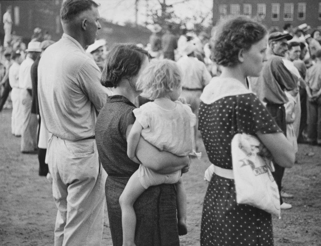 A group of people join the crowd of approximately 20,000 people who had gathered to witness the public hanging of Rainey Bethea.