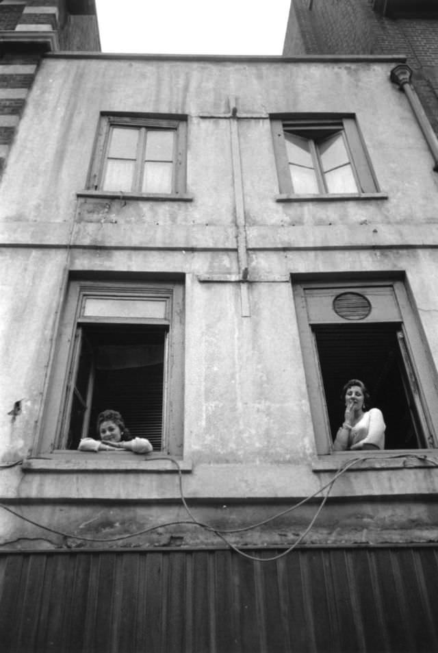 Two women leaning out the windows of a brothel, 1956.