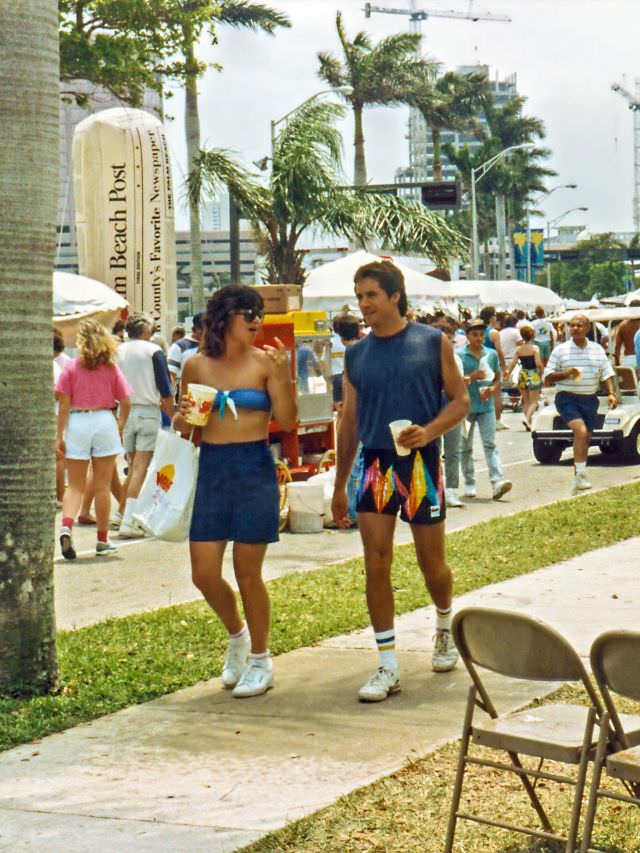 The couple walks by on a sidewalk, SunFest, 1988