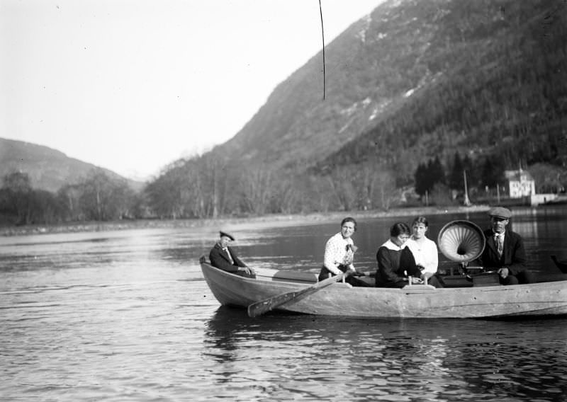 Five people in a rowing boat downstream on the river Jølstra from Hafstad Hotel in Førde