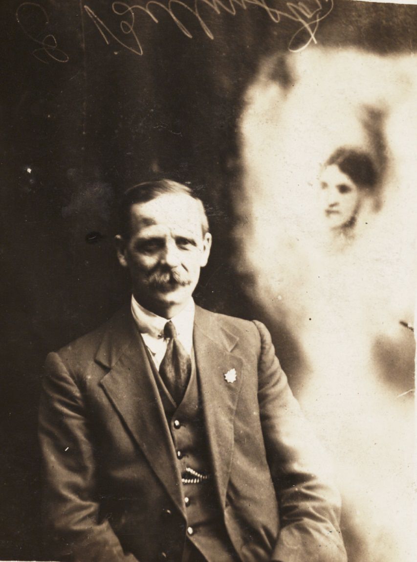 A man sits next to the "spirit" of his deceased first wife.