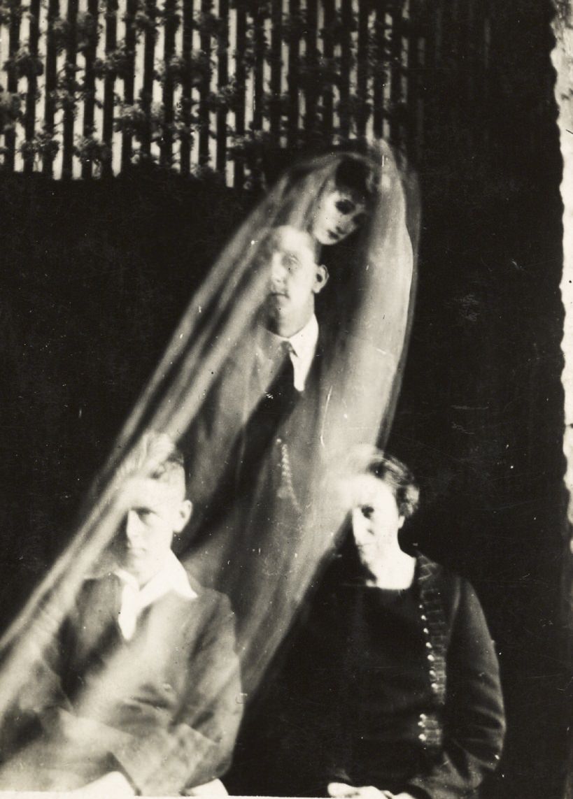 A cloaked woman's face appears over a group.