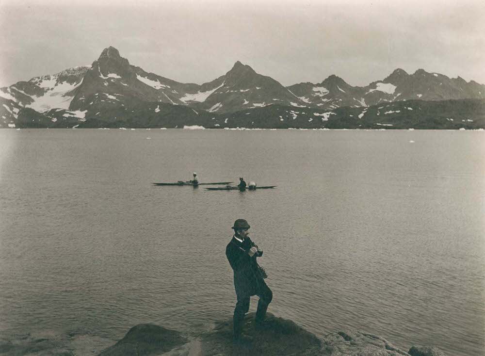 A self-portrait of photographer T.N. Krabbe standing over Tasiusaq Bay, 1890s