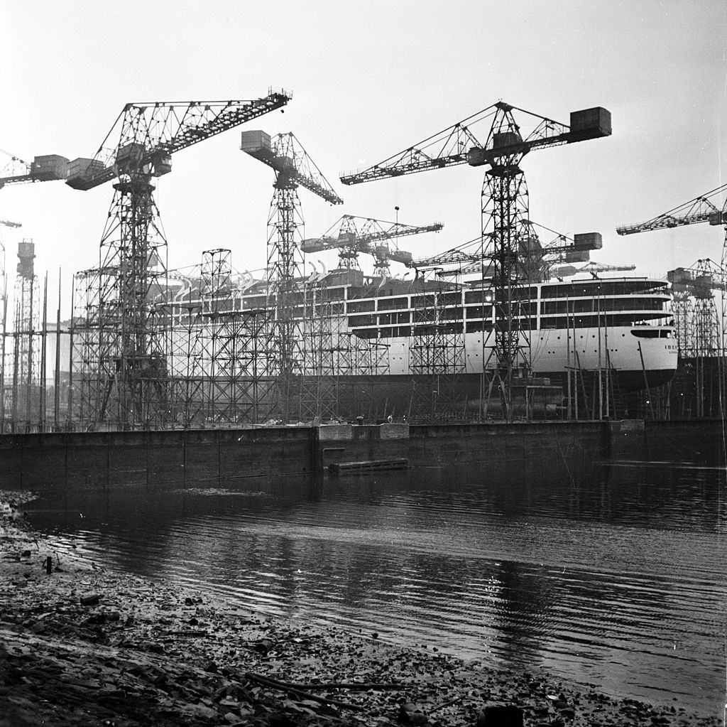 Cranes in Belfast shipbuilding yard surrounding a nearly finished ship, 1954.