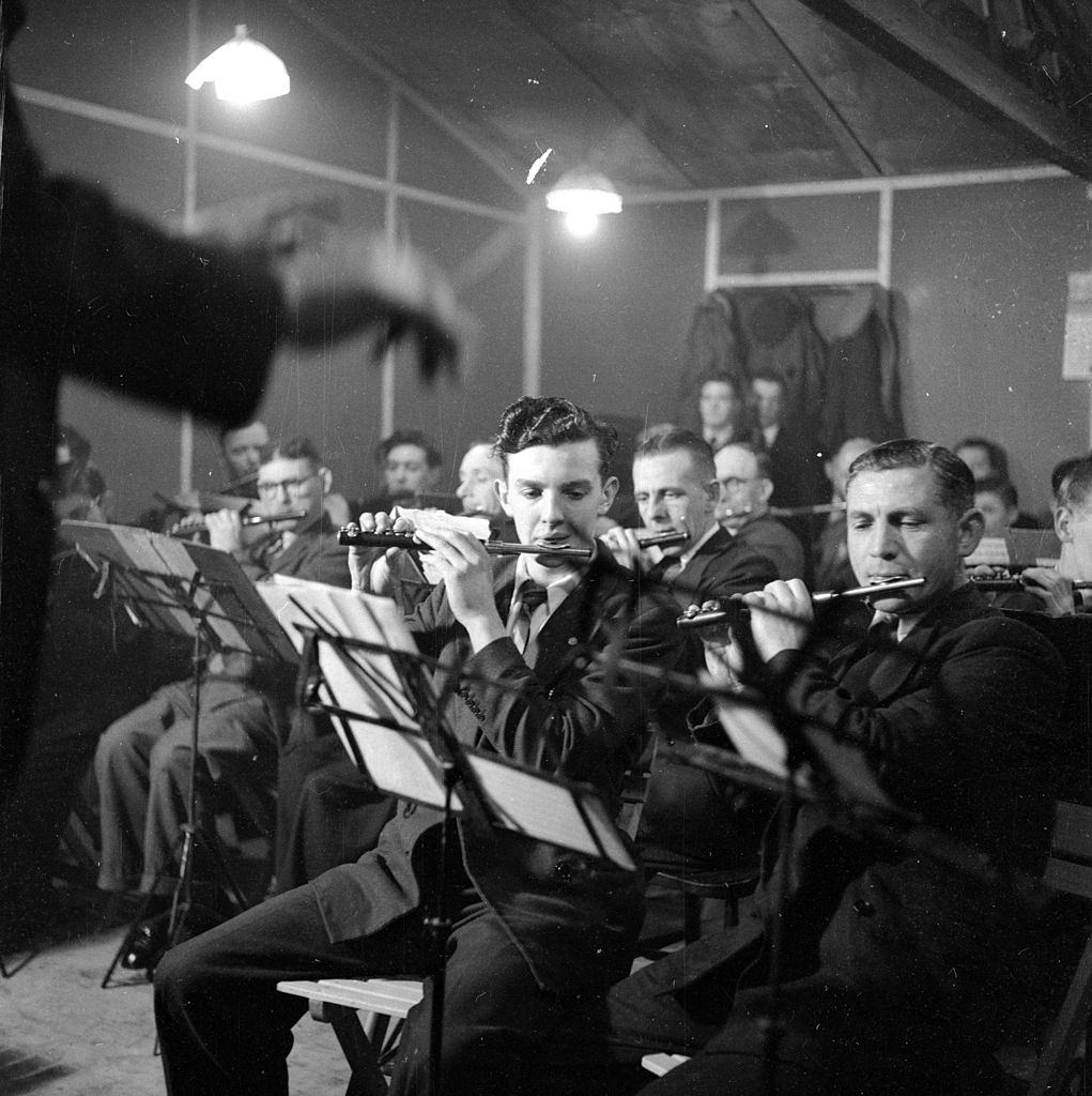 Men employed as shipyard or factory workers playing in a flute band in Belfast, 1954.
