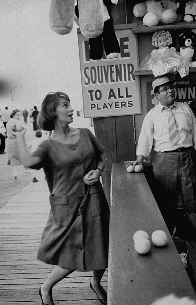 Actress Sophia Loren throwing a ball at a carnival, 1958.