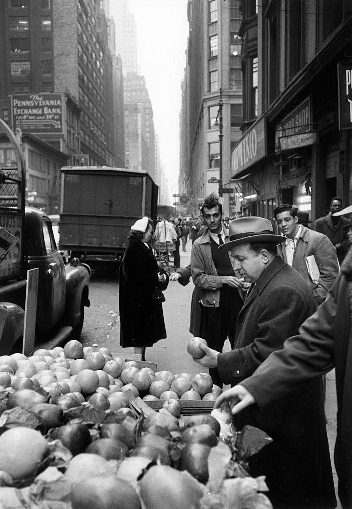 An Italian-American buying some fruit on a stall in the 38th Street in Brooklyn, 1956.