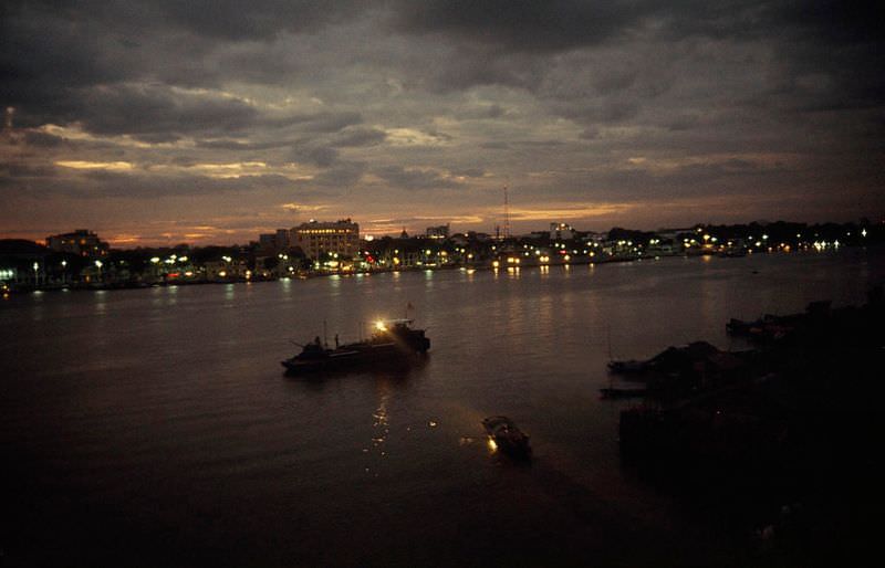 A nighttime patrol boat shines a searchlight on a sampan in Saigon, 1965