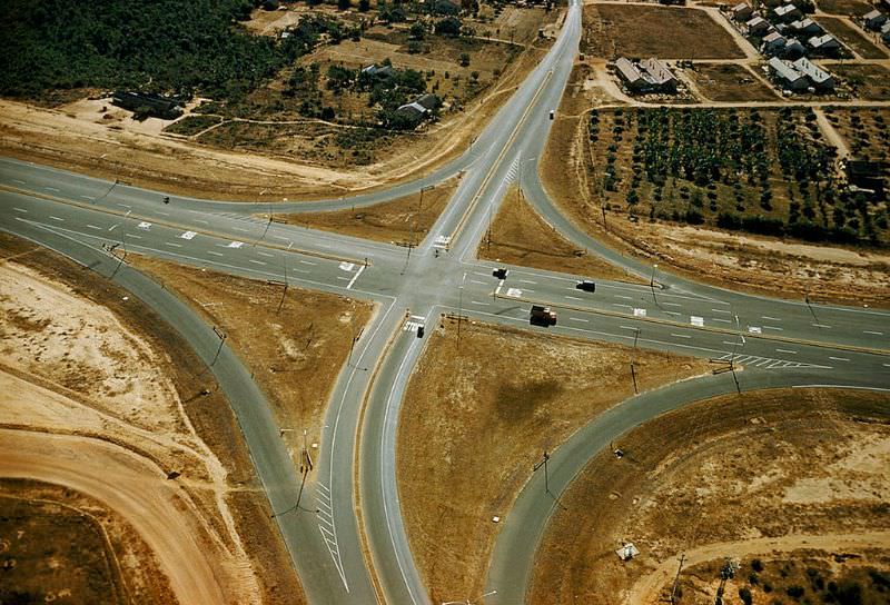 Few cars drive on a 20-mile highway to Bien Hoa built with U.S. aid, 1961