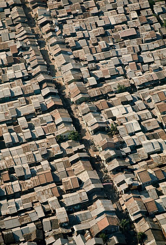 Shacks made of metal, wood, and cardboard jam a Saigon suburb, Cholon, 1965