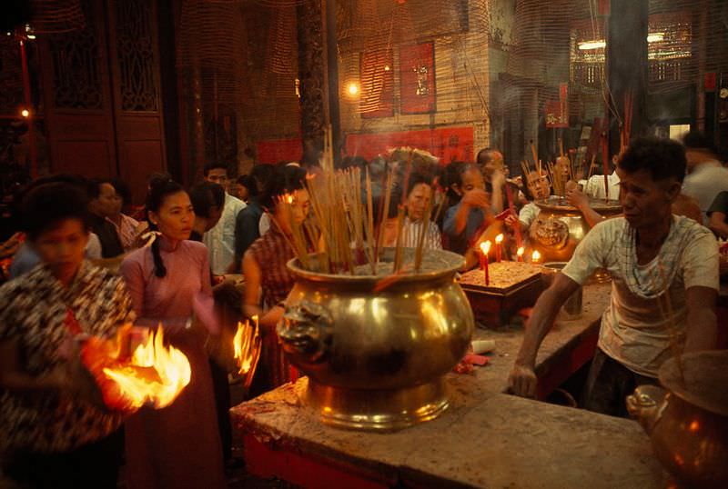 Supplicants burn joss sticks and votive papers in a Chinese temple, Cholon, 1965