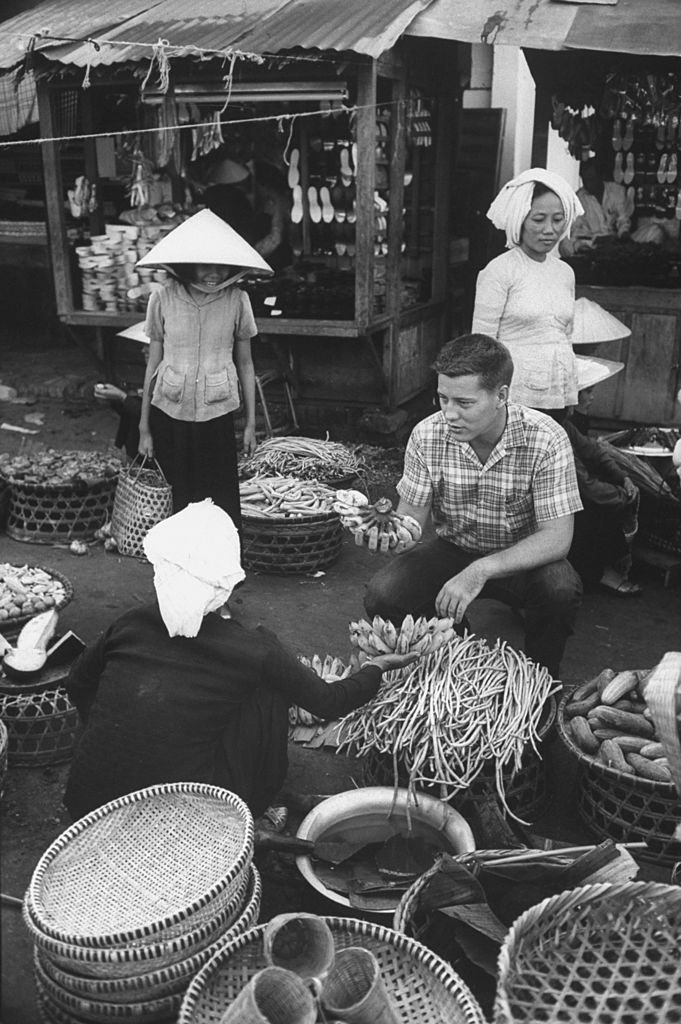 Volunteer Verle Lanier (center R) buying bananas at market, 1961.