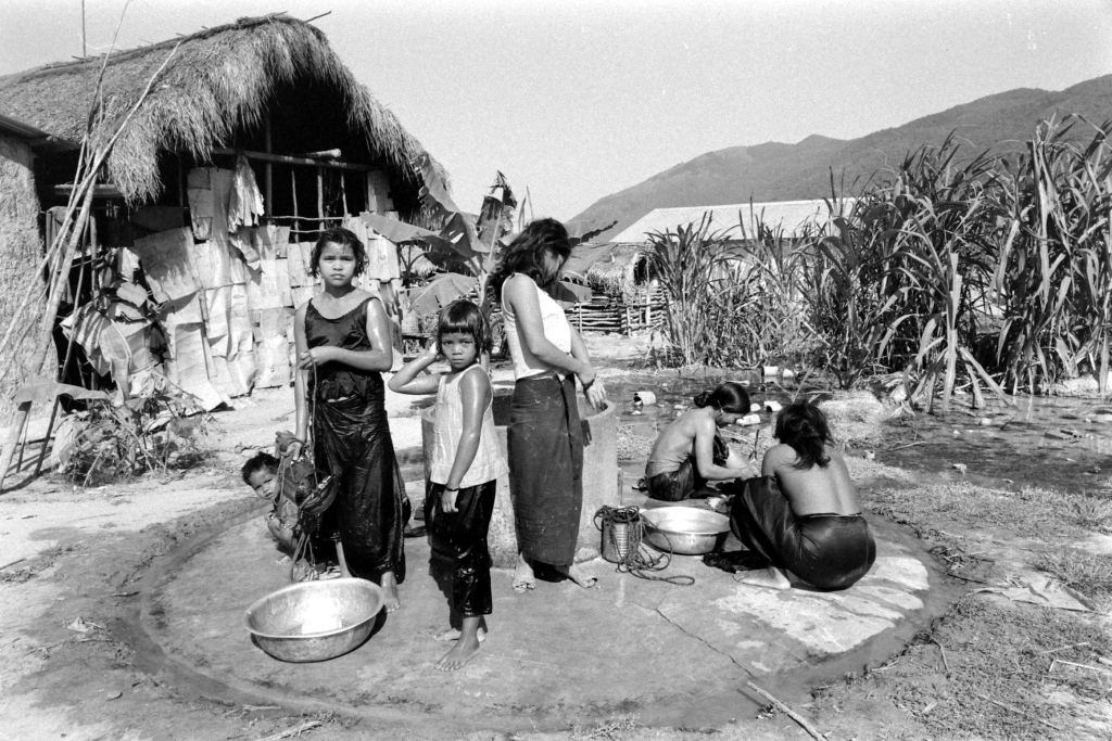 South Vietnamese refugees taking bath outdoor, Vietnam, 1964