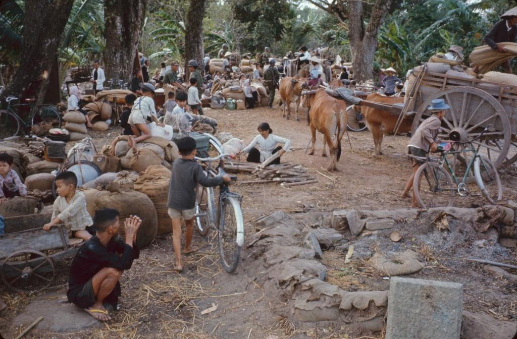 View of civilians and their belongings as they wait to evacute, as part of Operation Cedar Falls, from the Iron Triangle village of Ben Suc, Vietnam, 1967.