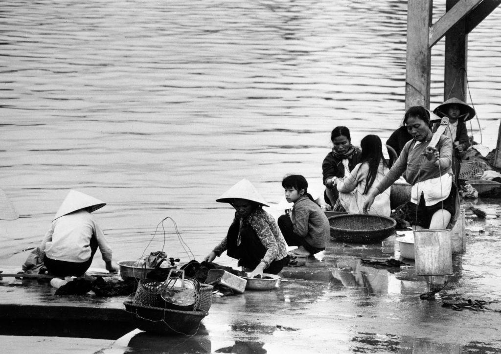 On the edge of the Perfume River, women do laundry in Hue, Vietnam on April 12, 1968.