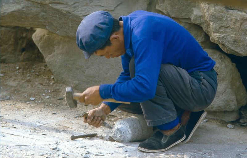 Chiseling out a stone pillar by hand