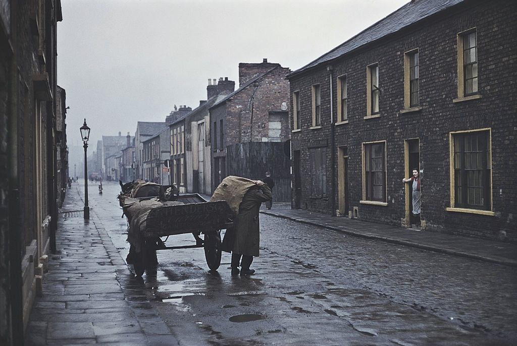 A man delivering sacks of coal from a horse and cart, Belfast, 1955.