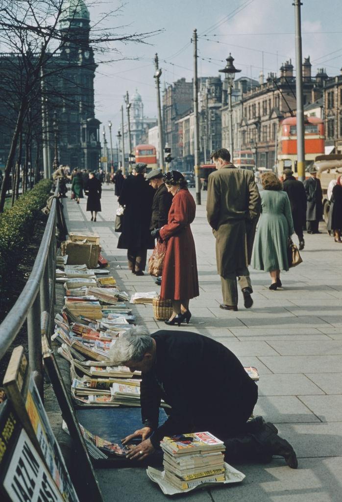 A man selling books and magazines in the street in Belfast, 1955.