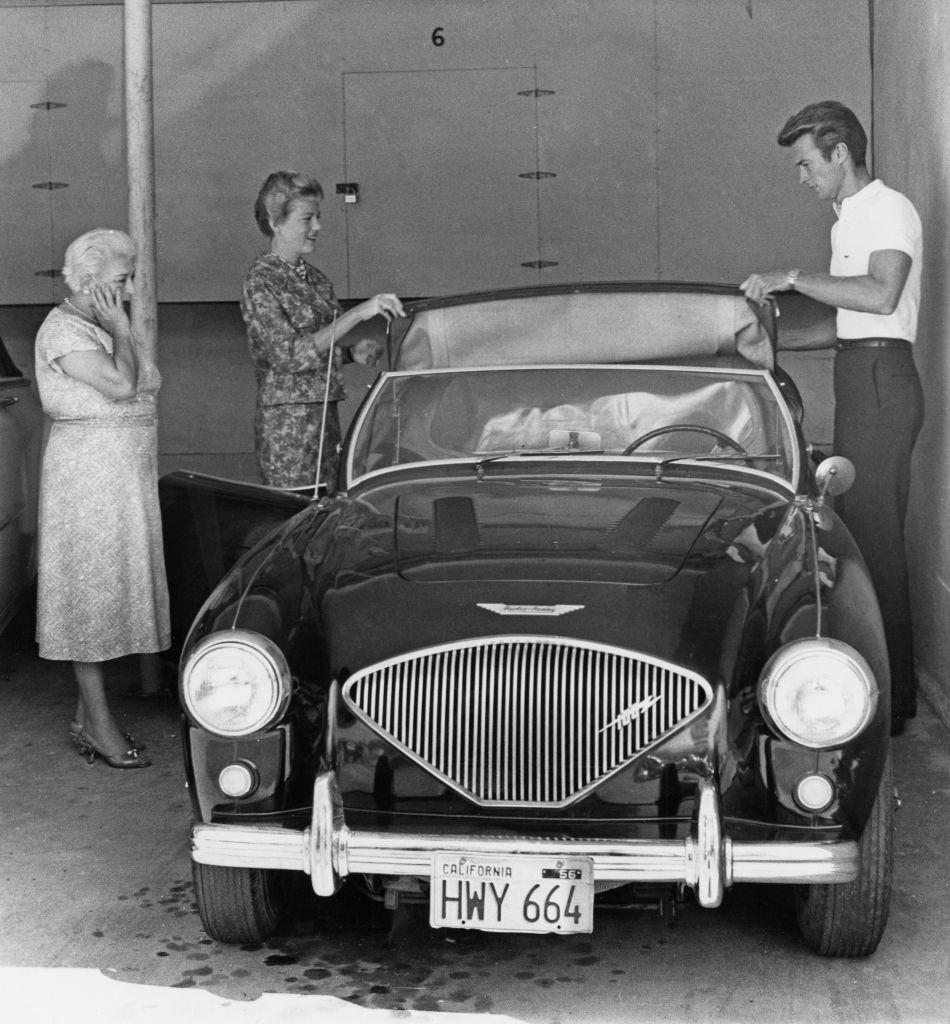 Clint Eastwood and with his wife Maggie Johnson adjusting the roof of an Austin Healey sports car, 1960.