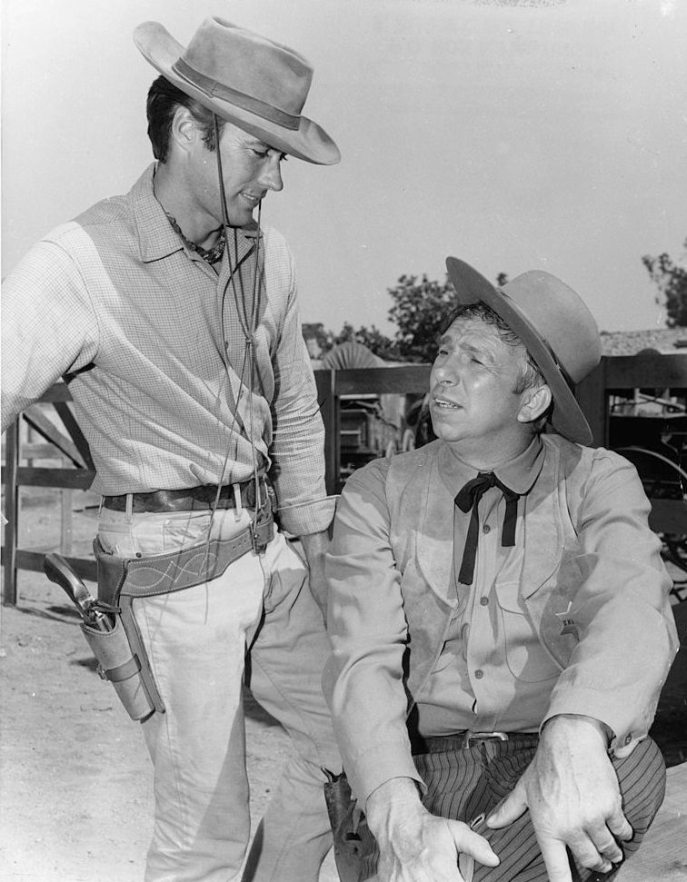 Clint Eastwood talks with Slim Pickens during a break from shooting the television series 'Rawhide', 1960.