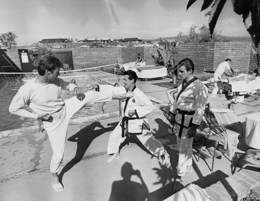 Clint Eastwood bring trained in karate next to a swimming pool,1960.
