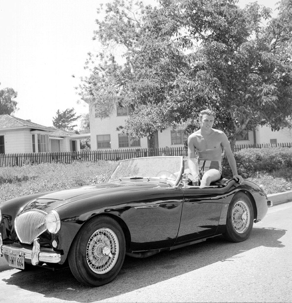 Clint Eastwood sits the back of a convertible Austin Healey sportscar, 1956.