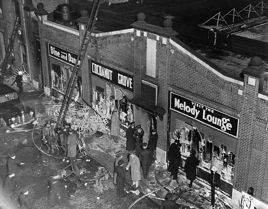 Police, firemen, reporters, and the curious gather at the entrance to the Cocoanut Grove nightclub in Boston on November 29, 1942.