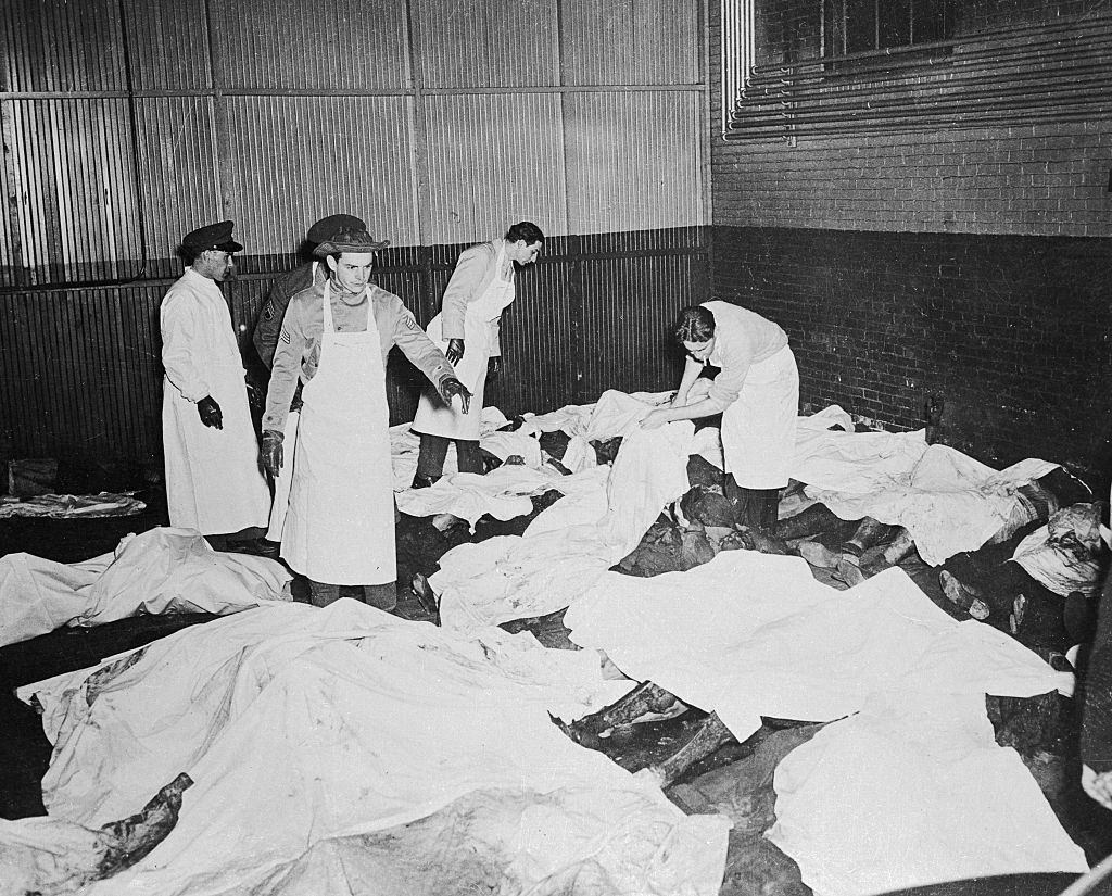 Men in the service of Uncle Sam donned white coats and aprons over their uniforms and assist in helping to identify victims of the fire at the morgue.