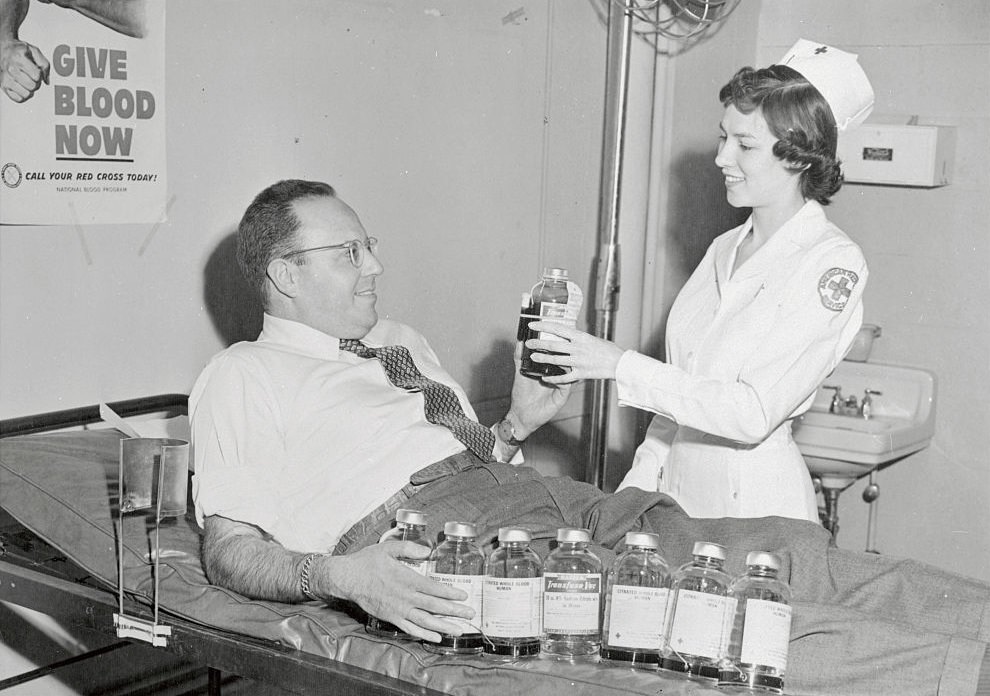 Martin Sheridan handing donated blood to nurse.