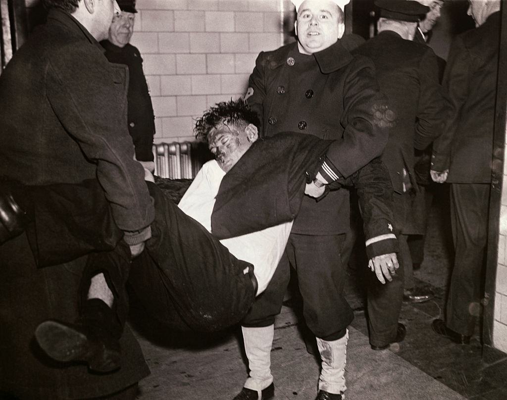 Two men carrying one of the victims of the Cocoanut Grove fire to safety.