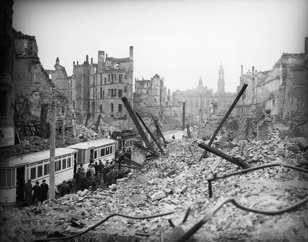 Residents of Dresden line up for a streetcar amid the ruins of the city.