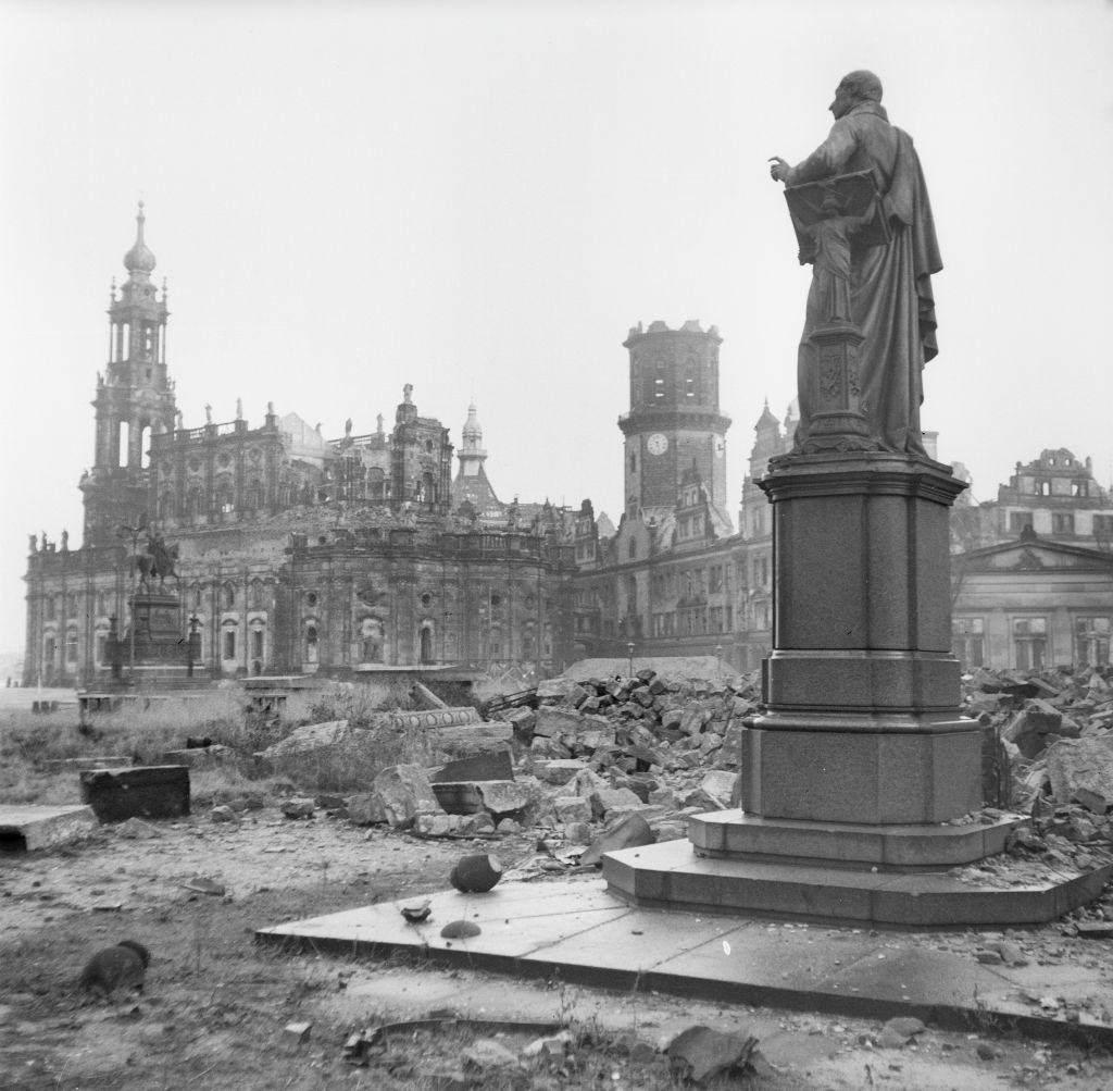 The Carl Maria von Weber monument (right), the Theatre Square and the ruins of the Dresden Cathedral (left) and the Dresden Castle with Hausmannsturm.