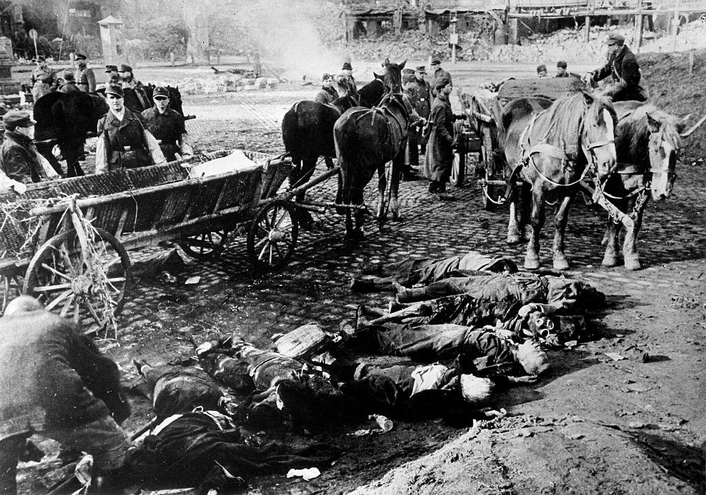 In the heap of rubble of the city centre, some soldiers unload from two carts the bodies of some victims of the violent bombing of the allied forces of February 13 and 14.
