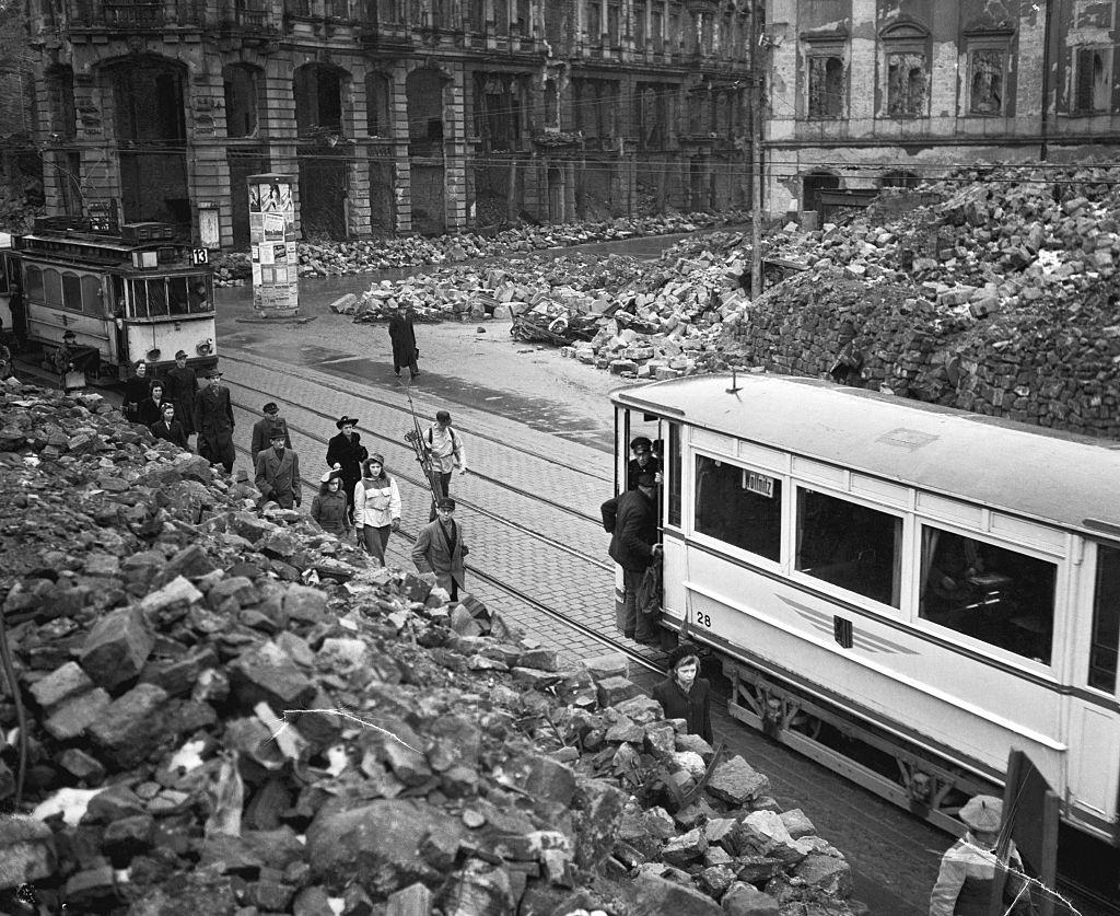 People step out of a tram car to view the destruction of a entire town, 1946.