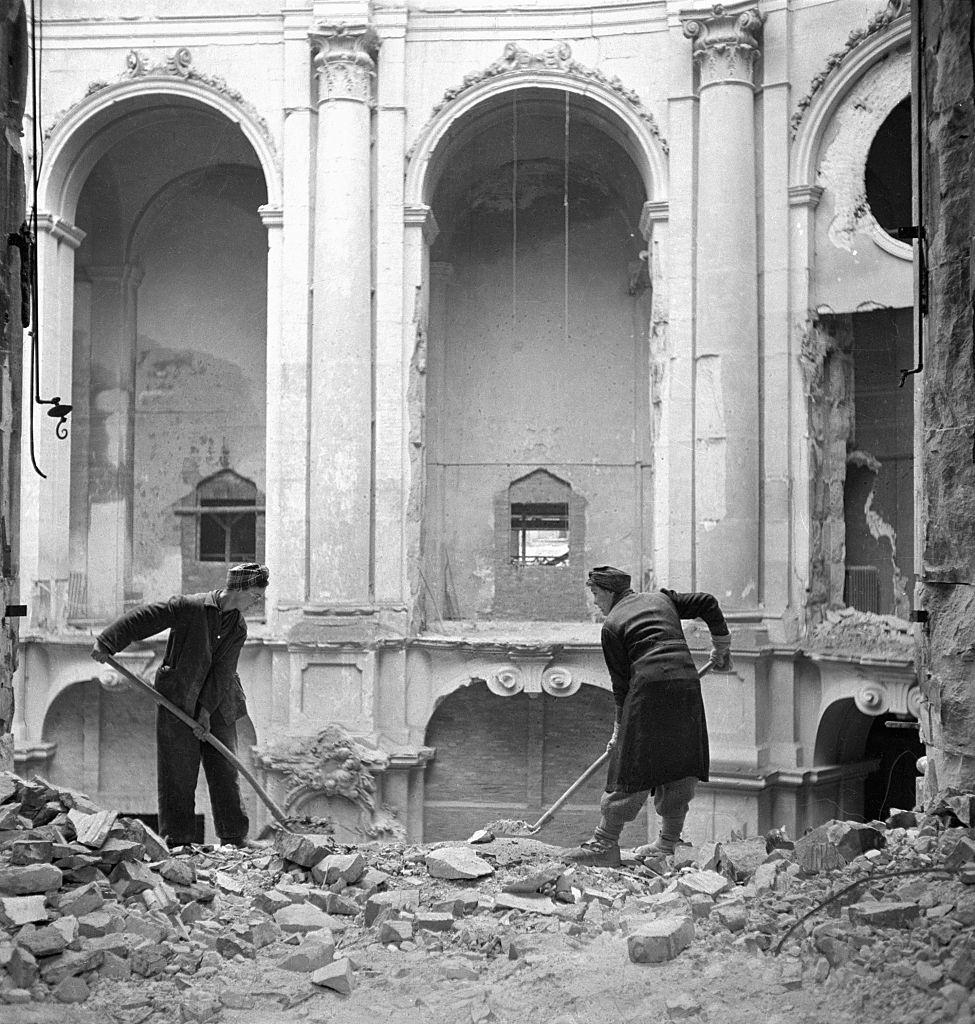 Workers shovel debris inside a heavily damaged building in Dresden.