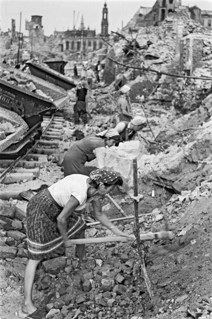 Women working on a rubbish heap next to the Trümmerbahn (a railway to transport rubble) in the old city of Dresden.