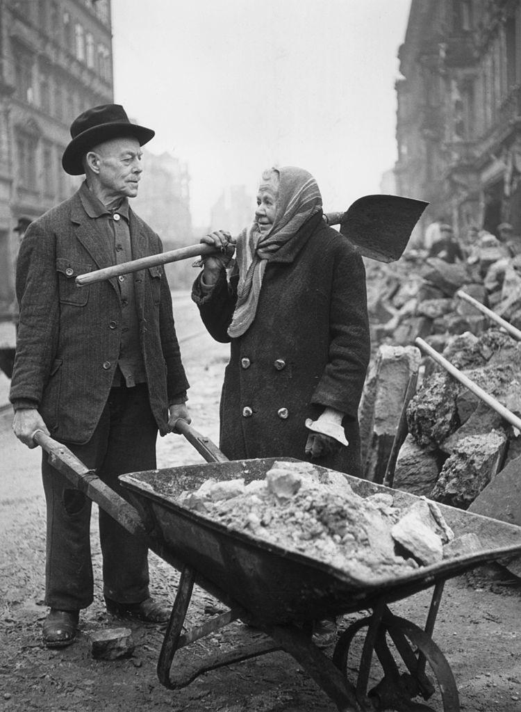 An elderly couple do their best to help clear the debris during the post-war reconstruction of bomb-damaged Dresden, 1946.