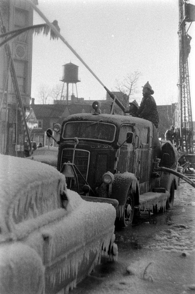 Firefighters spraying water during winter in Chicago, Illinois, 1958