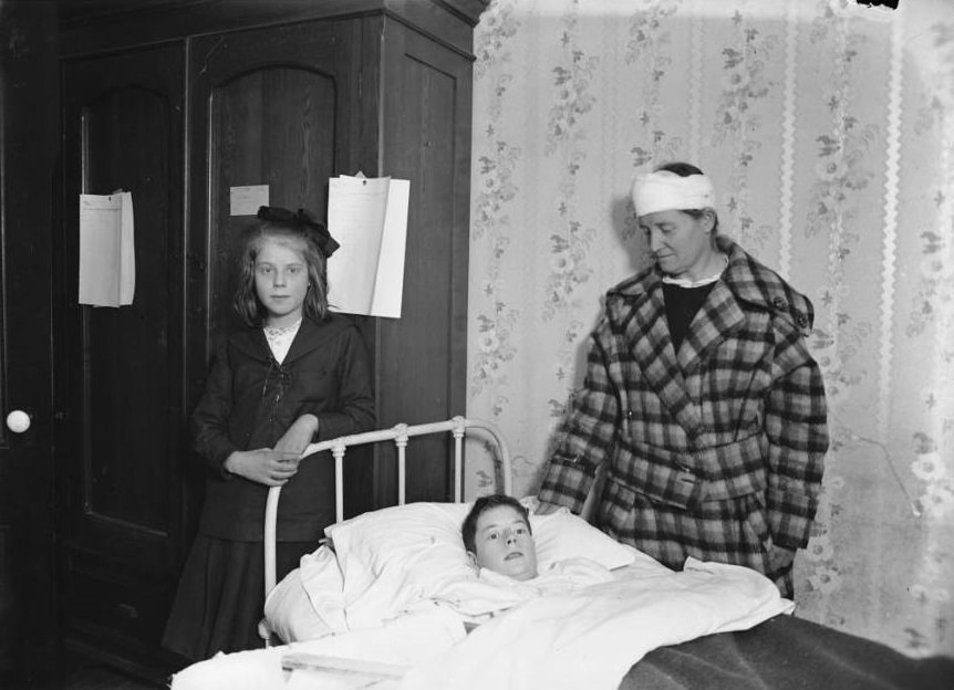 A family stands vigil over their wounded child's bed.