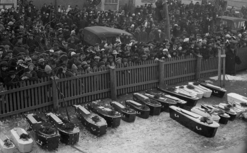 A crowd gathers to watch the funeral for the 2,000 who died in their city.