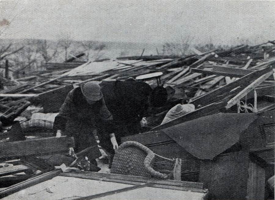 Two survivors sift through the ruins of what was once their home.