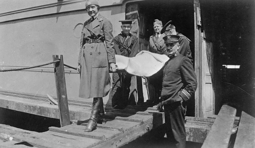 American Red Cross workers help carry a wounded man to a makeshift hospital set up nearby.