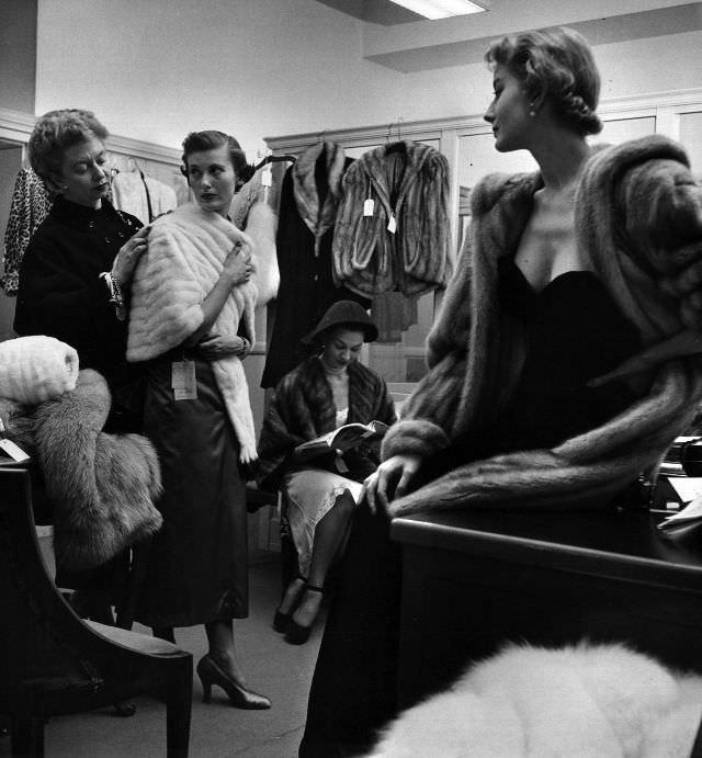 Women trying on furs in the dressing room.