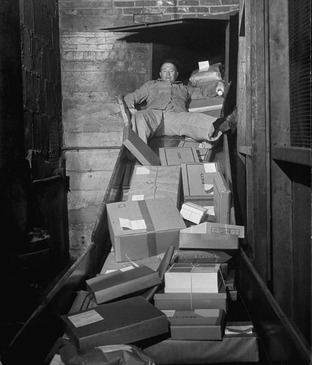 An employee clearing the package chute with his body.